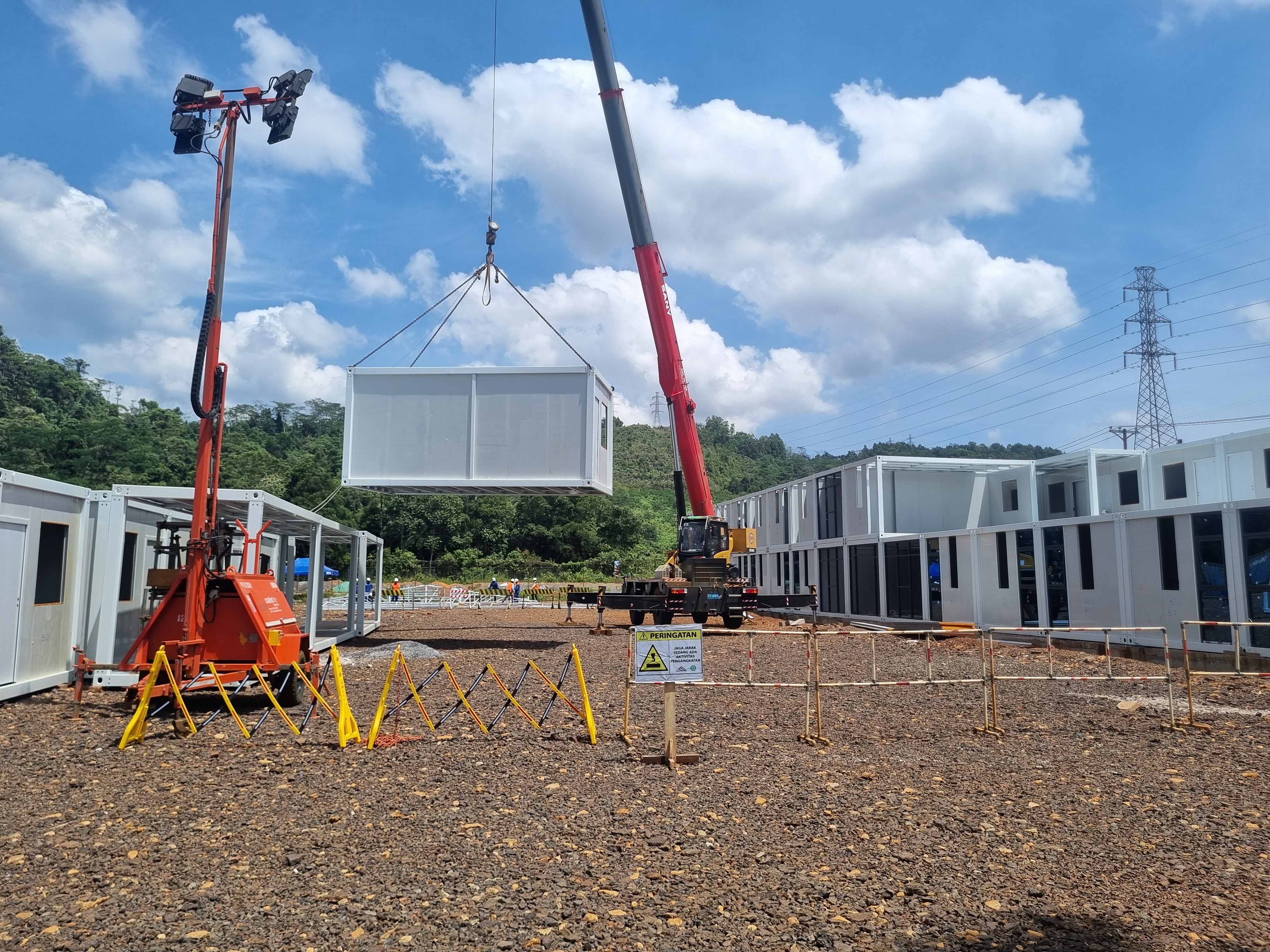 A PT Lis Karya modular unit being lifted into position at an industrial site